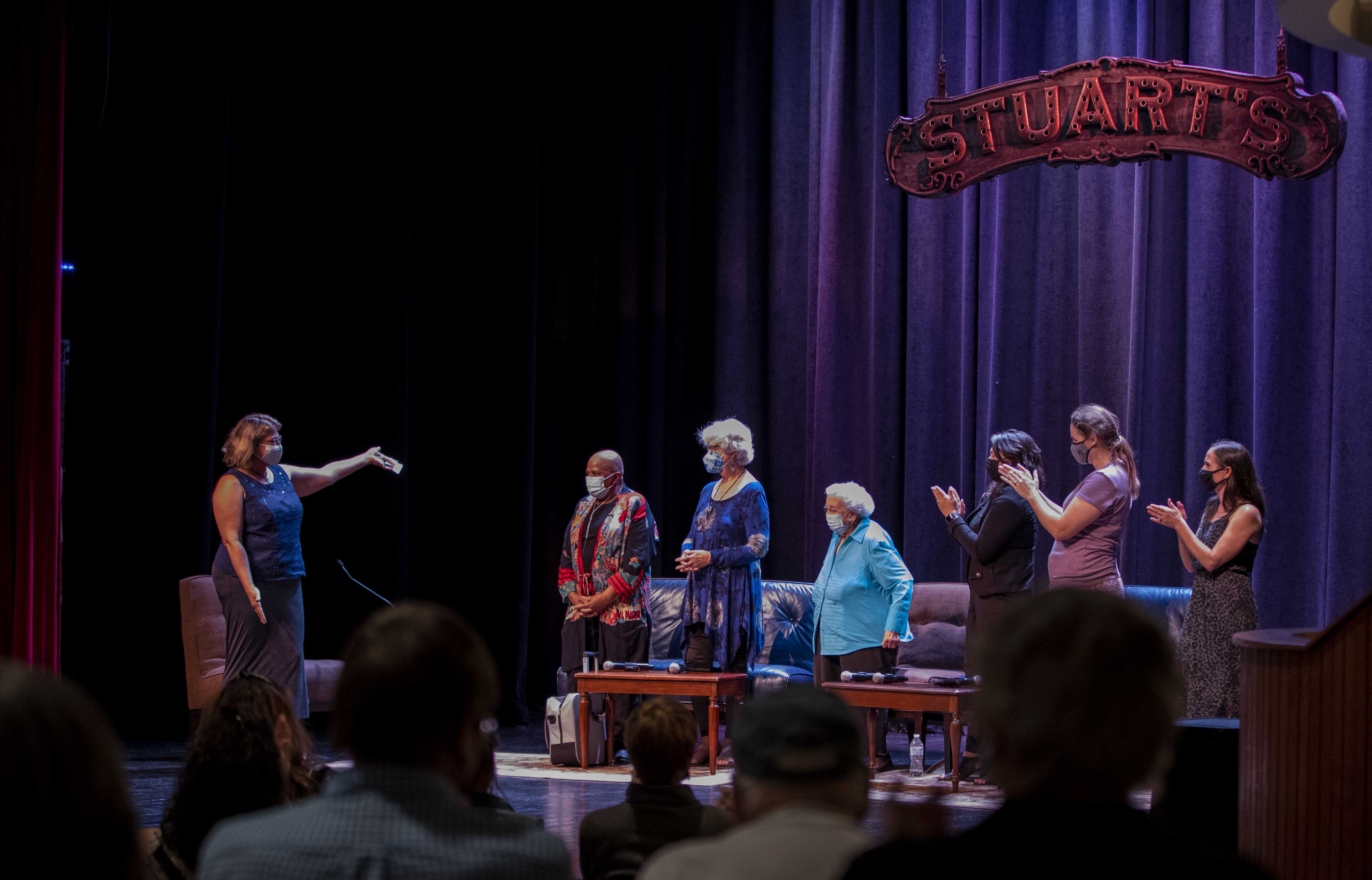 Seven women on stage for a panel discussion.